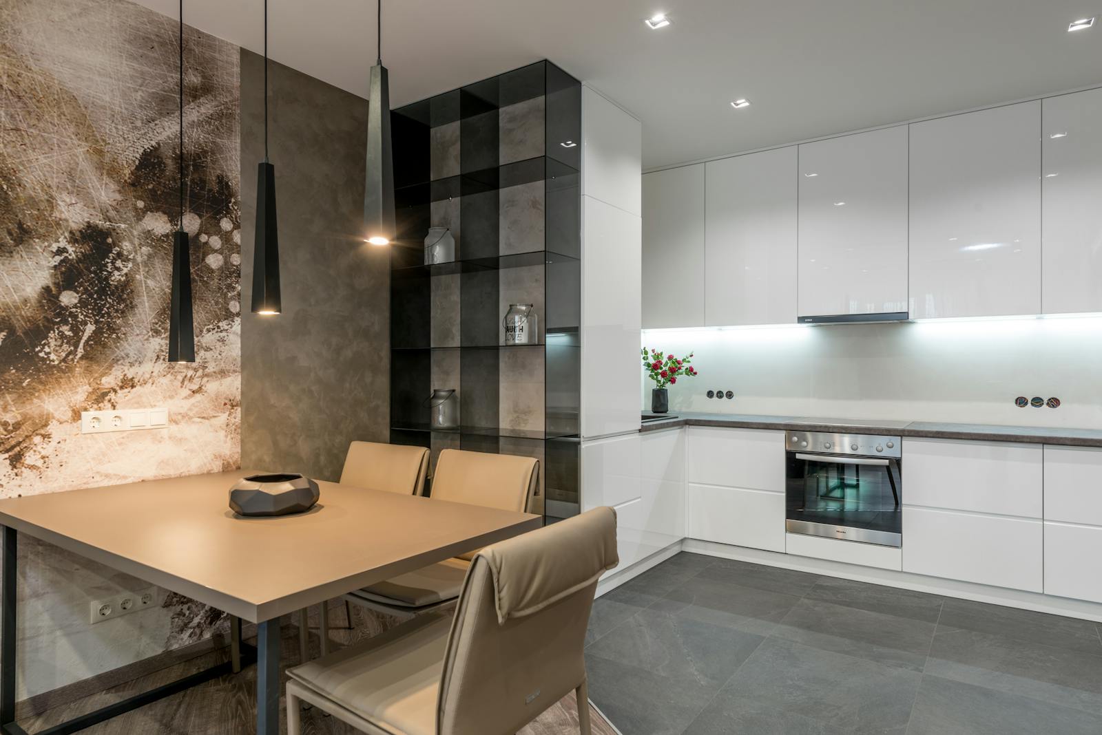 Photo by Max Vakhtbovycn Wooden dining table with comfortable chairs placed in modern spacious kitchen with white cupboards and contemporary appliances