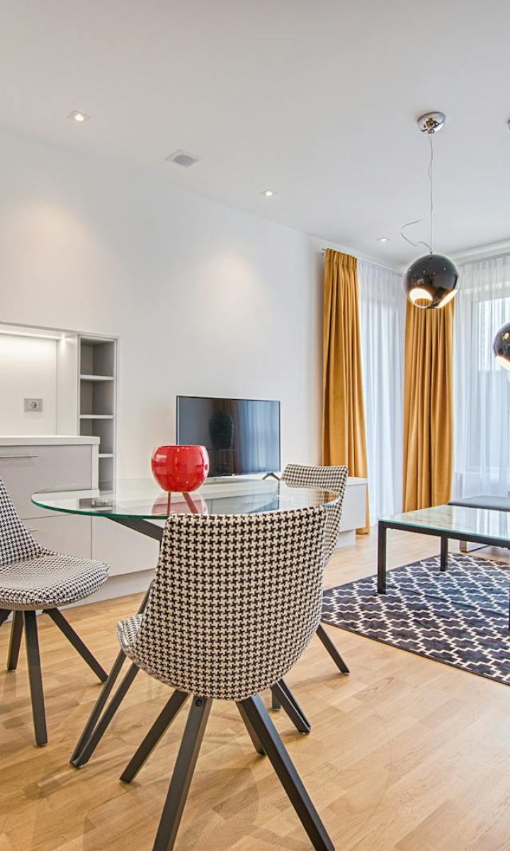 Photo by Vecislavas Popa Elegant Scandinavian-style living room and kitchen featuring modern furniture and decor.