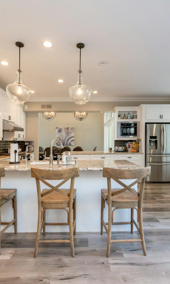 Photo by Terry Magallanes Bright and spacious kitchen interior featuring bar stools and modern design elements.