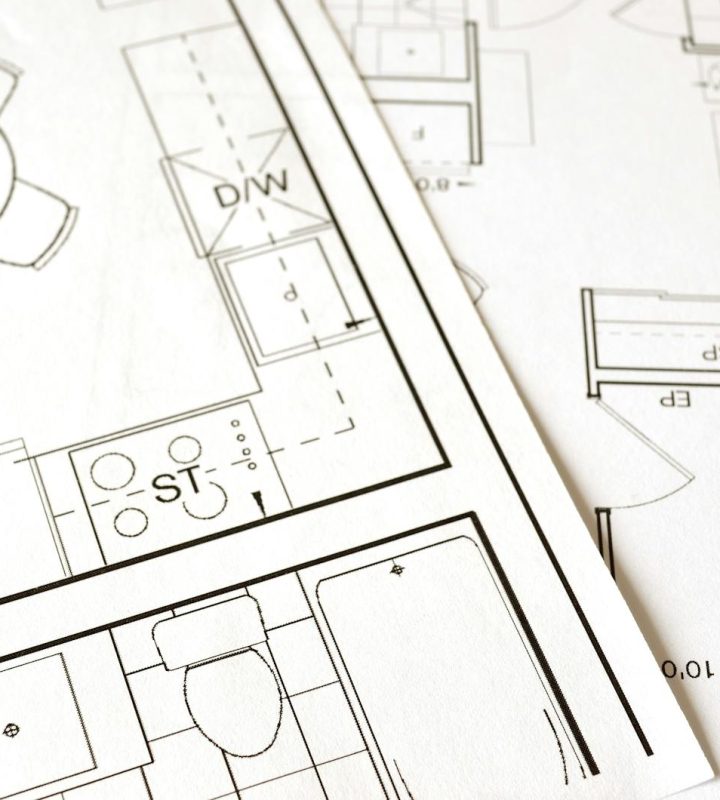 Close-up view of an architectural floor plan on paper showcasing detailed room layouts and measurements.