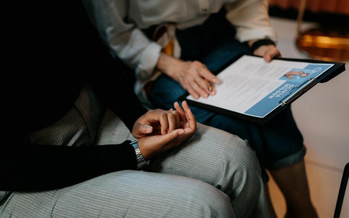 Two professionals reviewing a resume in an office setting, focused on teamwork.