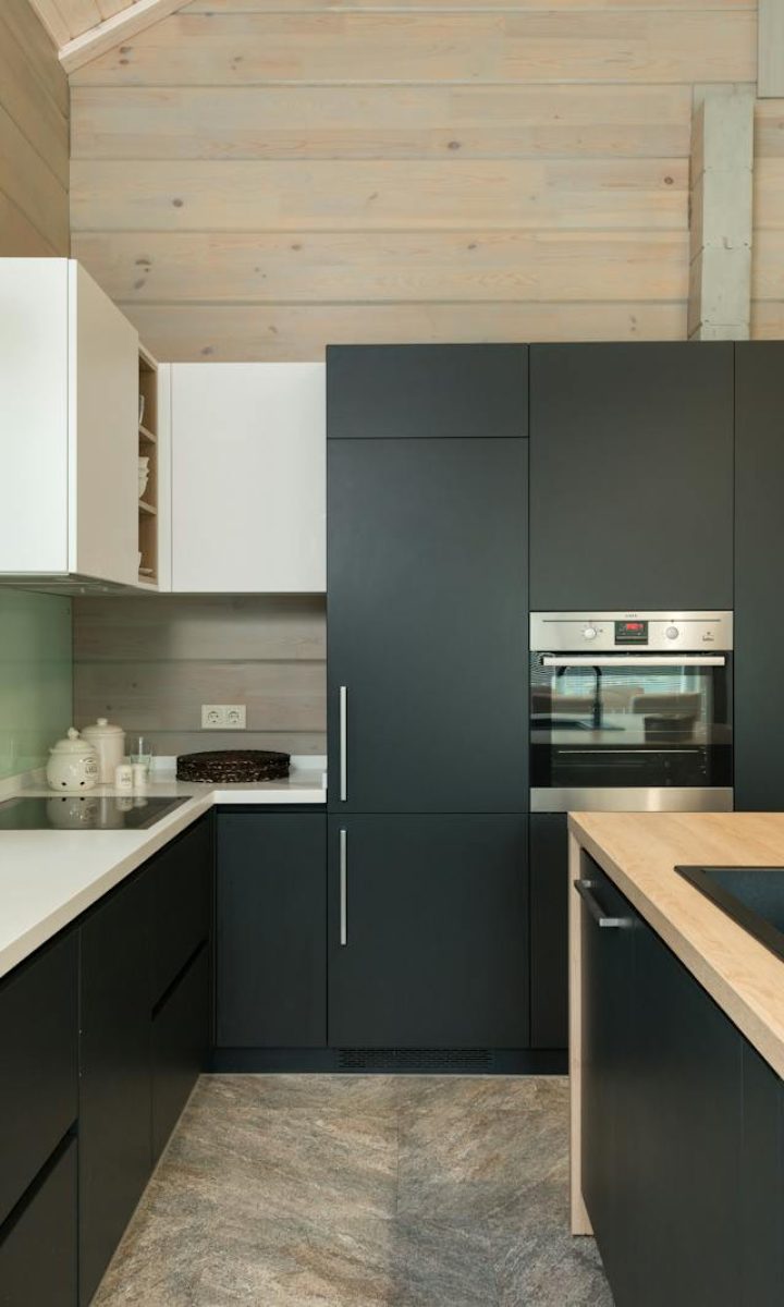 Photo by Max Vakhtbovycn Sleek black and white kitchen with wooden accents and contemporary design.